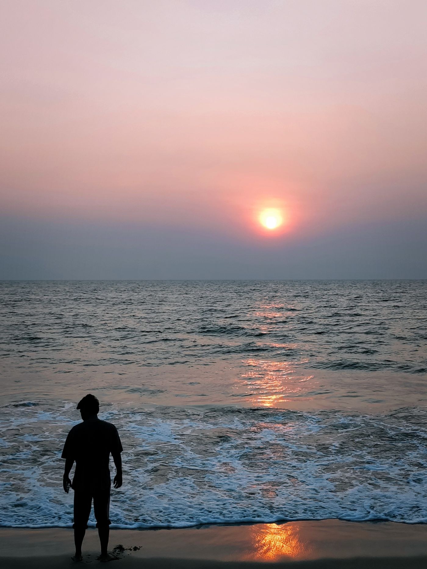 Silhouette einer Person am Meer bei Sonnenuntergang