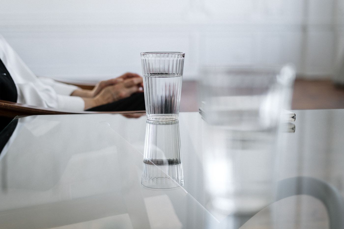 Wasserglas und seine Spiegelung auf einem Tisch