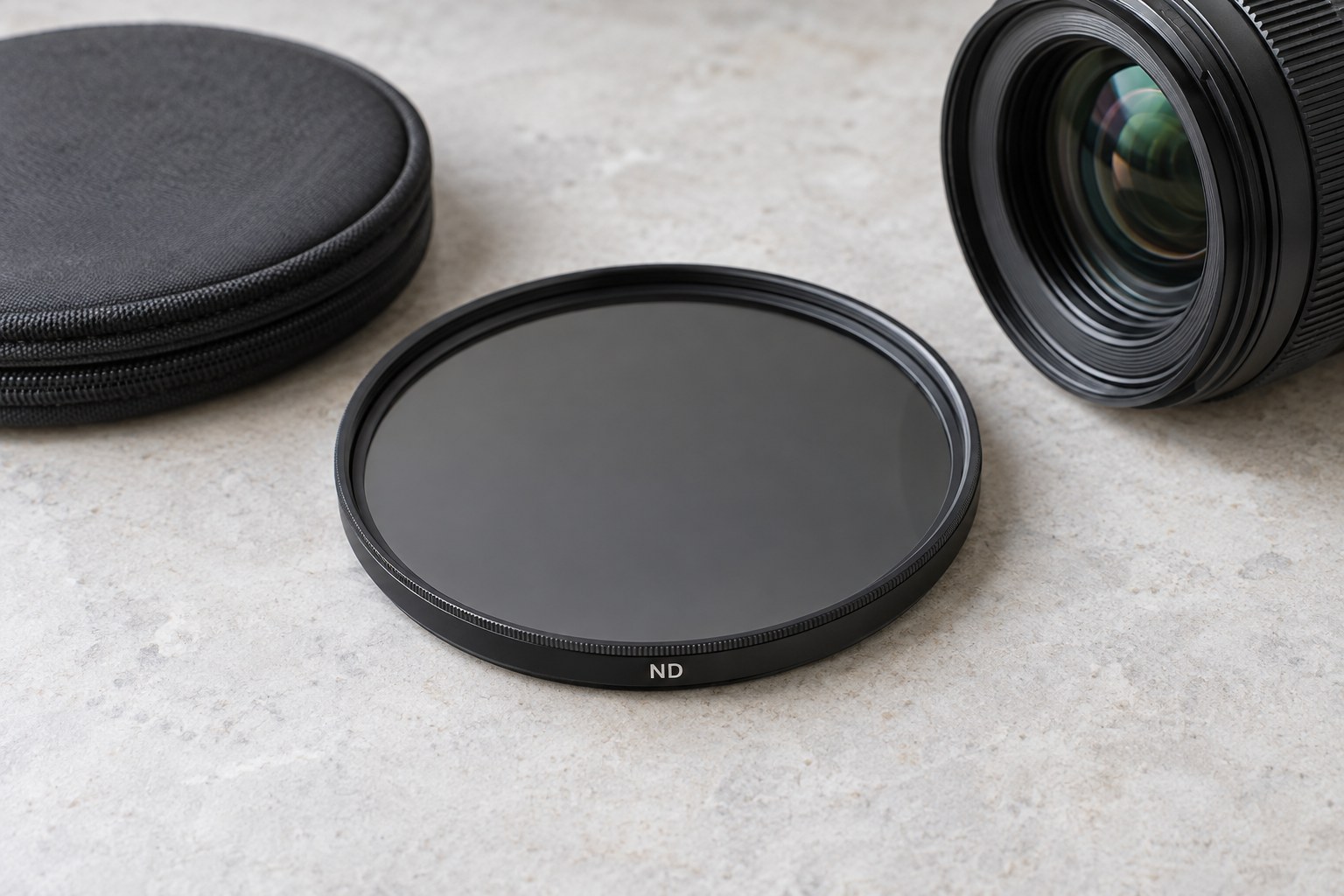 Dunkler runder ND-Filter neben Objektiv und Etui